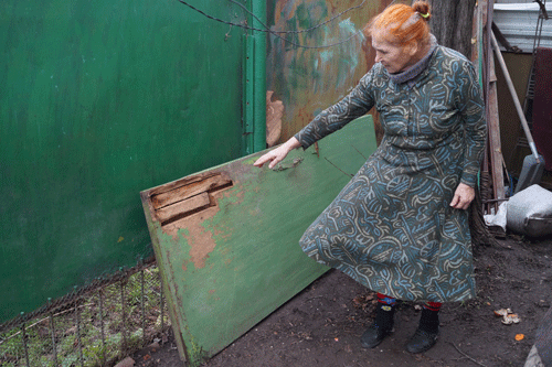 Хозяйка дома показывает сломанную дверь Хозяйка дома показывает сломанную дверь