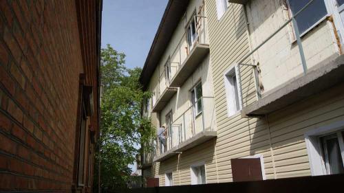 Чуть больше двух метров отделяет окна спальни пенсионеров от входа в подъезд многоэтажки. Фото Александра Кондратьева.