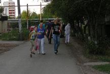 Люди и машины курсируют по узкой дороге.